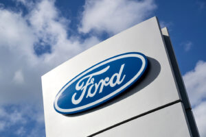 Ford logo on tall vertical signage against blue sky